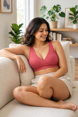Crossover nursing bra in red on a smiling model relaxing on a sofa, wire-free comfort | maternity feeding bra, Zelena