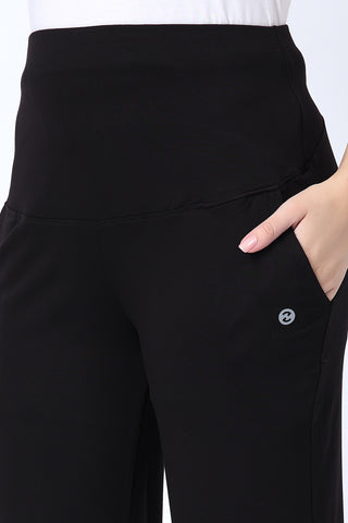 Model wearing Black Flared Pants; high waist panel offers abdomen support during phases.