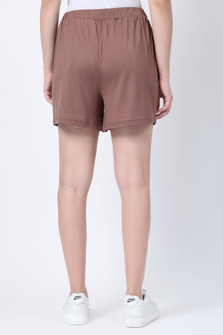 Model wearing Mocha Mid-Rise Shorts; sits below belly for support and cooling.