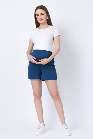 Model wearing Deep Teal Shorts; garment stretches to accommodate the growing bump.