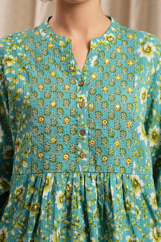 Detail shot of Cotton fabric; shows stretch and sea-green color/print.