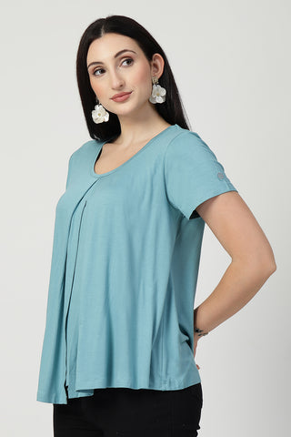 Detail shot of Viscose fabric; shows stretch and light-sea-green color/print.